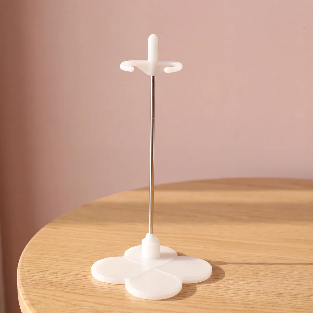 Neo Blythe Colorful Doll Stand 2 White Blythe doll stand with waist grip and clover base on a blush pink background