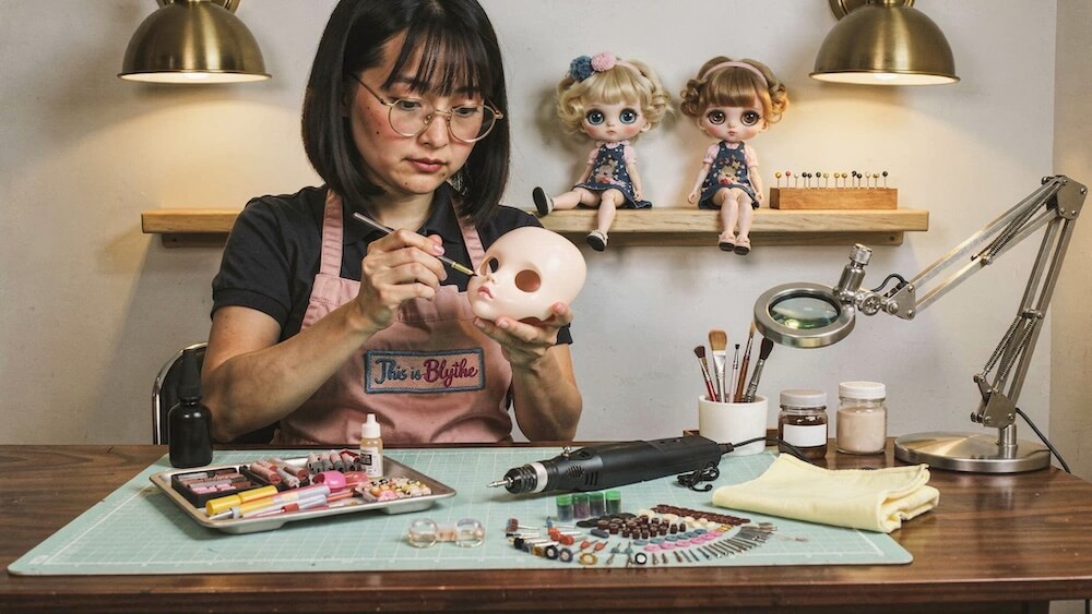 A This Is Blythe artisan hand-finishing a custom Blythe doll in the studio
